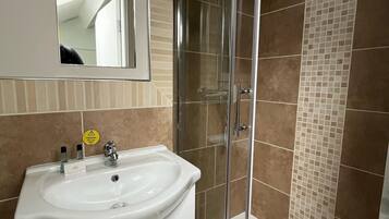 Standaard eenpersoonskamer | Badkamer | Een haardroger, handdoeken, zeep, shampoo