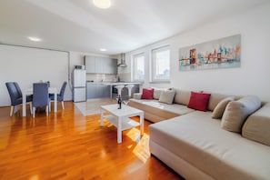 Un appartement moderne comprenant un coin repas, une cuisine et un salon.
