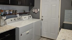 A compact kitchen with dark cabinets, a white stove, and a door.