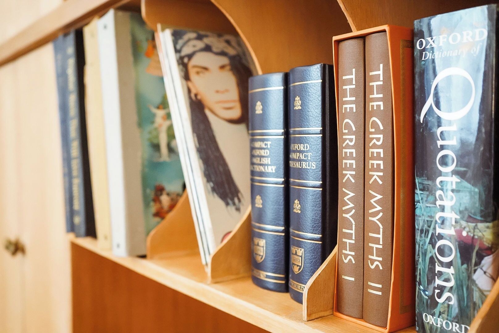 A bookshelf with books, including 'The Oxford Dictionary of Quotations' and 'The Greek Myths'.
