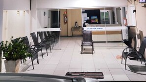 A reception area with a counter, chairs, and a potted plant. - Hotel Líder (Caceres)