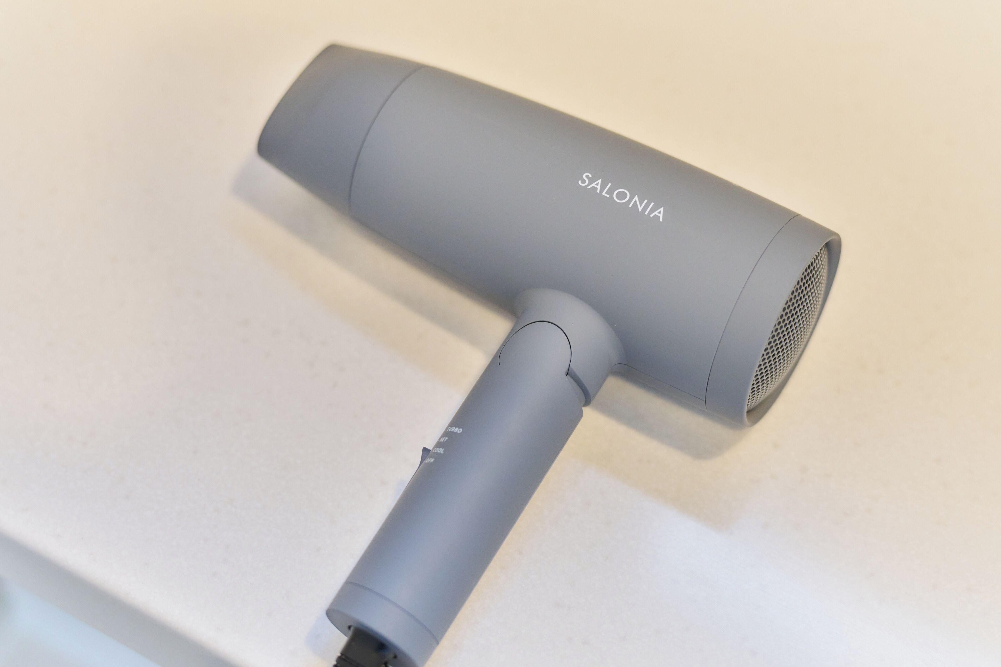 A grey hair dryer with the brand name 'SALONIA' on it.