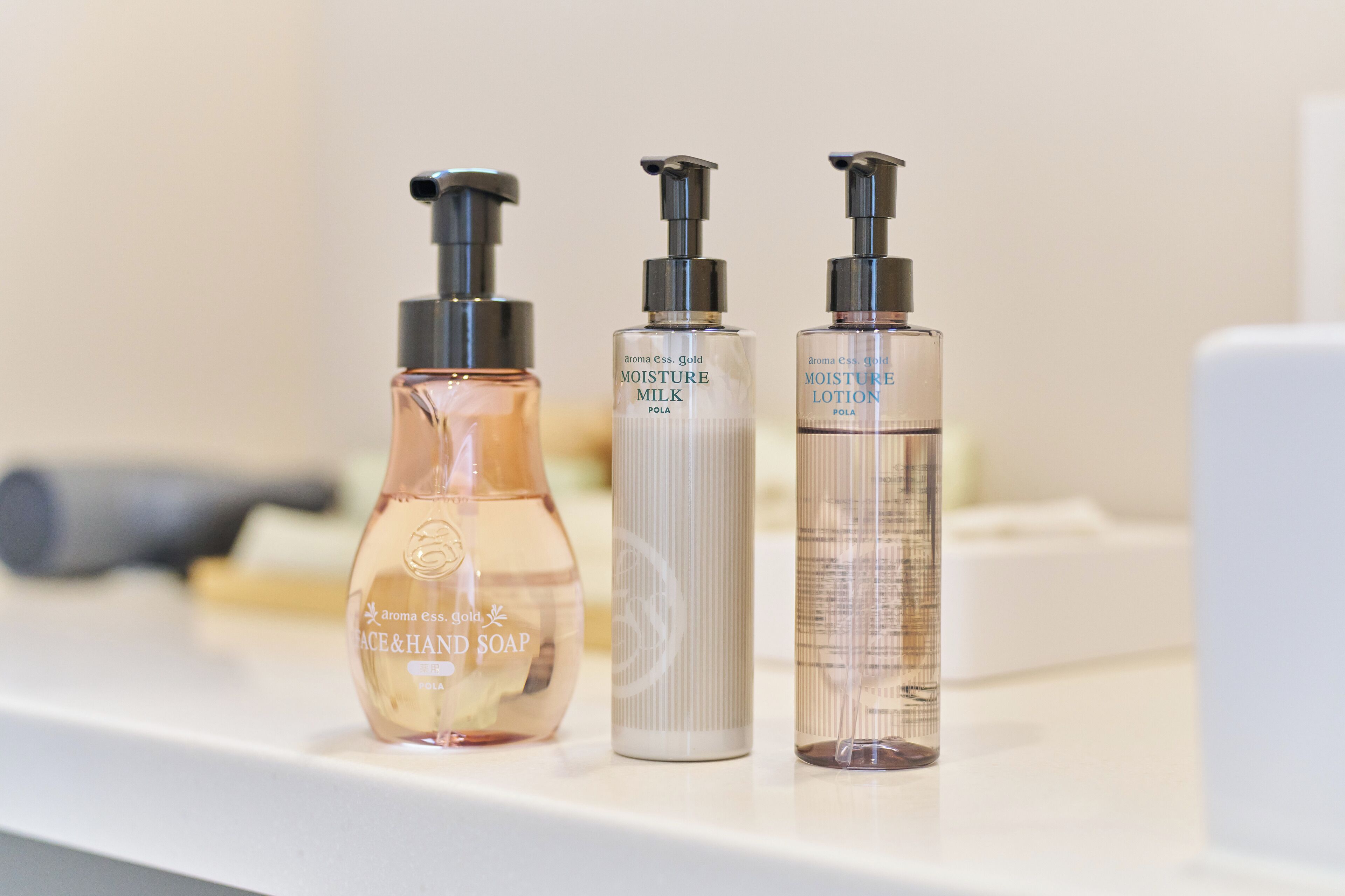 Three toiletry bottles on a white shelf.