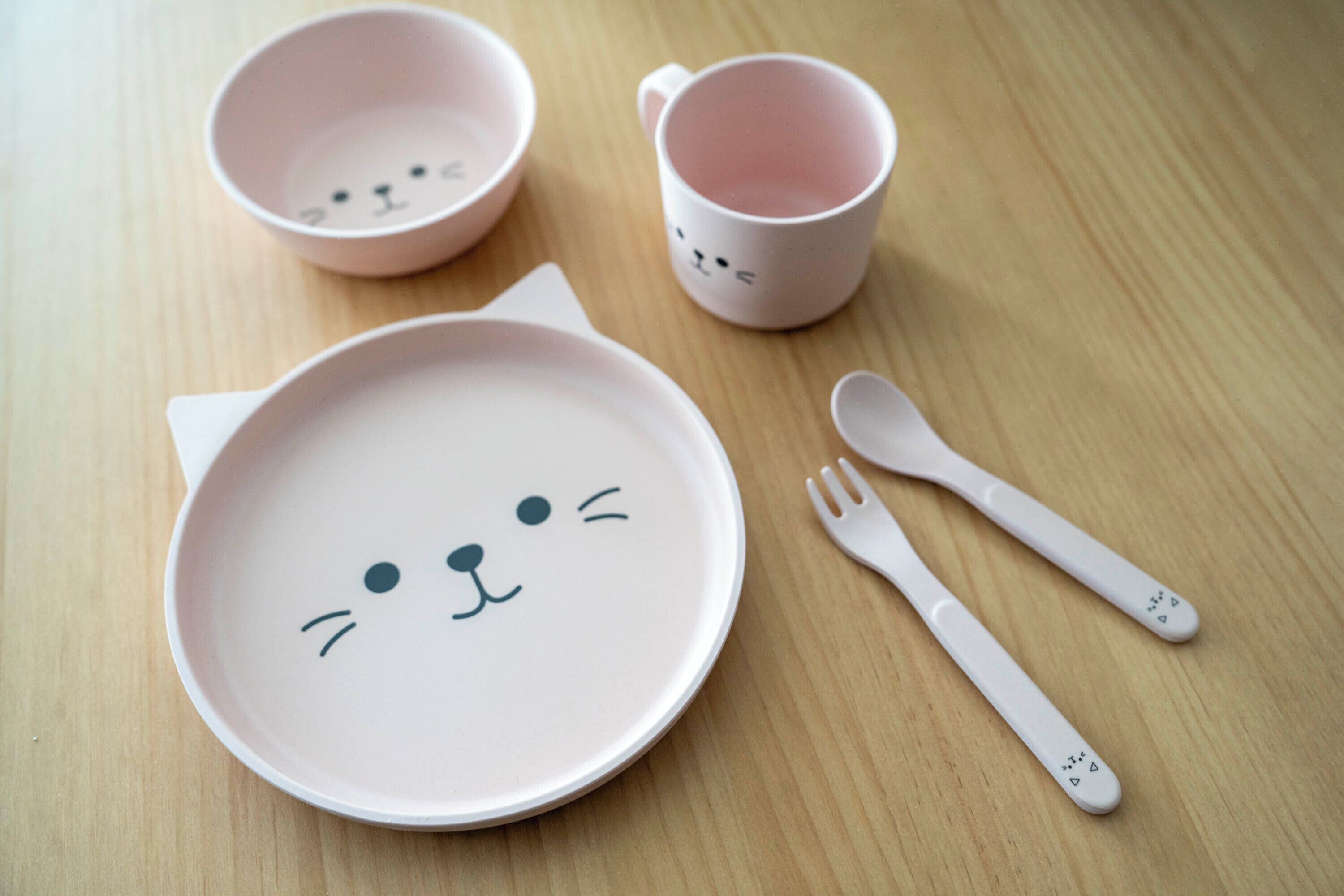 A table with a pink plate, a pink mug, and a fork.