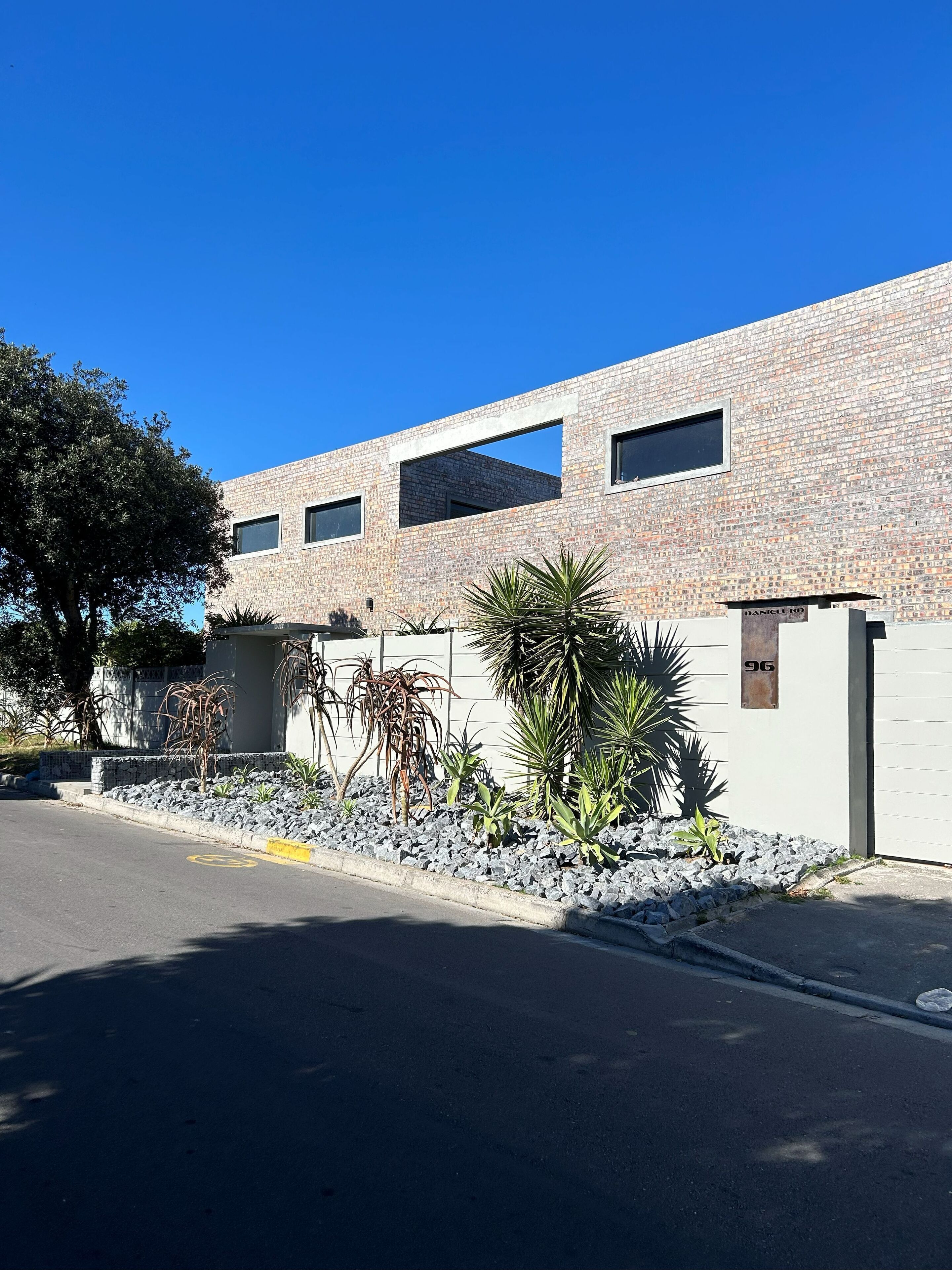 Un edificio moderno con fachada de ladrillo, varias ventanas y una entrada portonada.