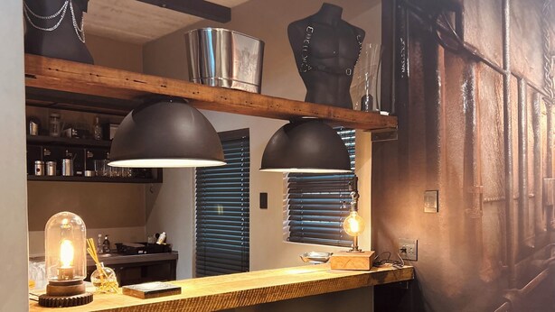 A bar area with a wooden counter, black bar stools, and pendant lighting. - The Citadel @ Tether&Tease, Extraordinary BDSM Location in Cape Town (Cape Town)