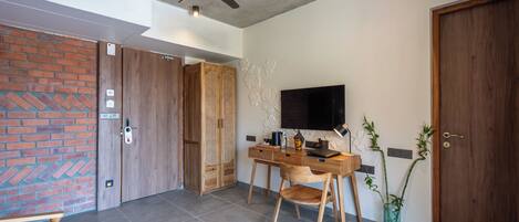 A modern room with a desk, chair, and a television.
