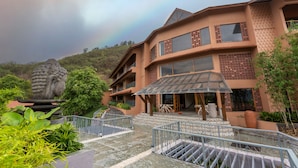 A multi-story building with a modern design, featuring large windows and a covered outdoor area.
