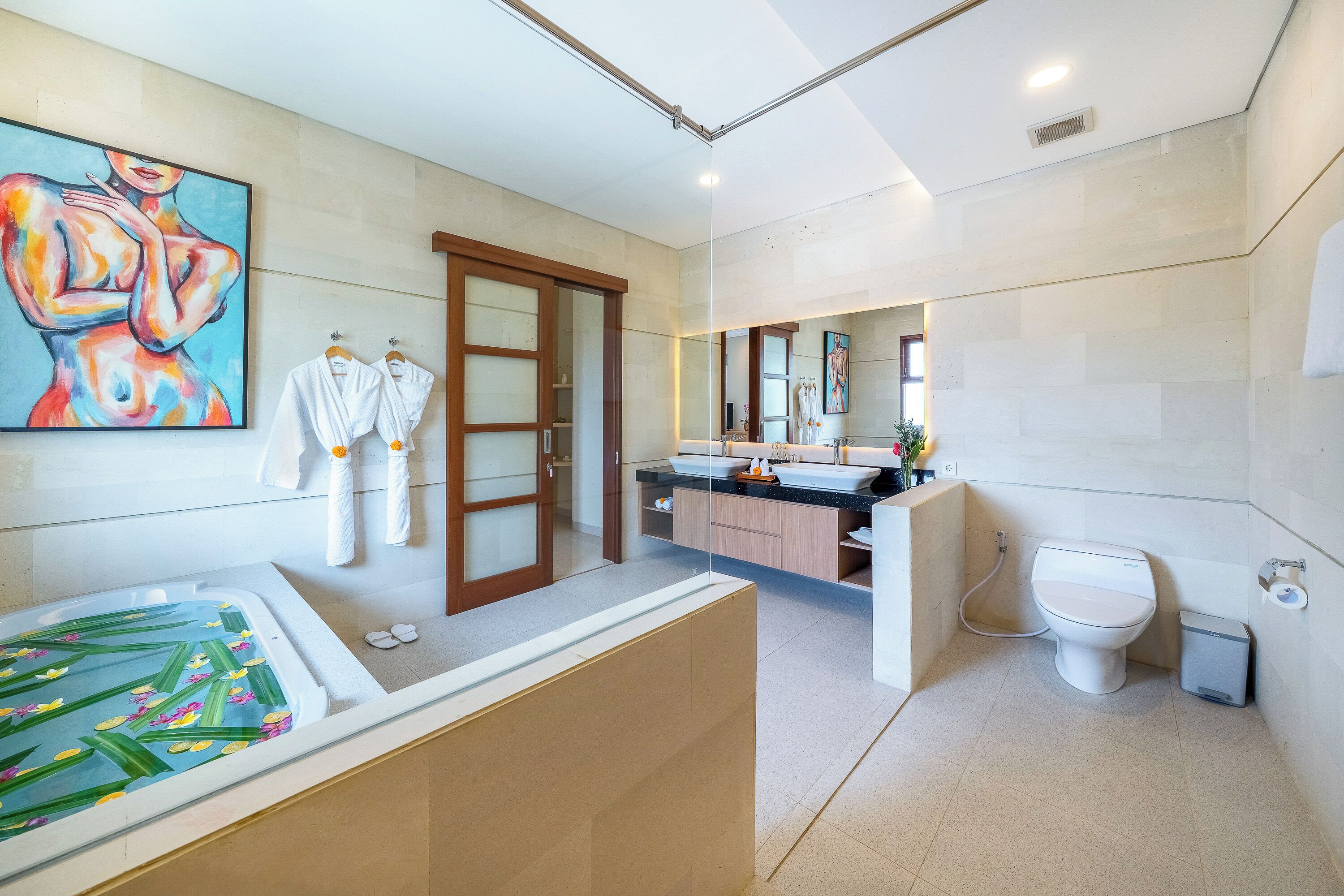 A modern bathroom with a bathtub, toilet, and sink.