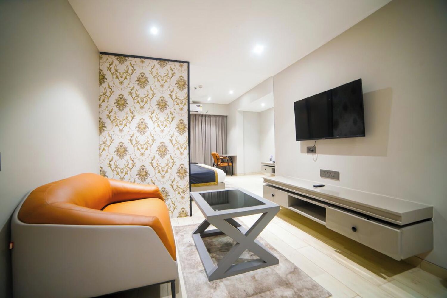 Una sala de estar moderna con un sofá, una mesa de centro y un televisor montado en la pared.