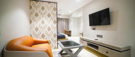 Una sala de estar moderna con un sofá, una mesa de centro y un televisor montado en la pared.
