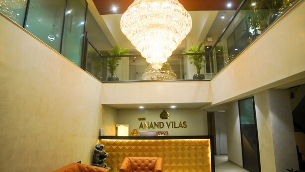 A hotel reception area with a chandelier, reception desk, and seating. - Hotel shri anand Vilas (Bhopal)