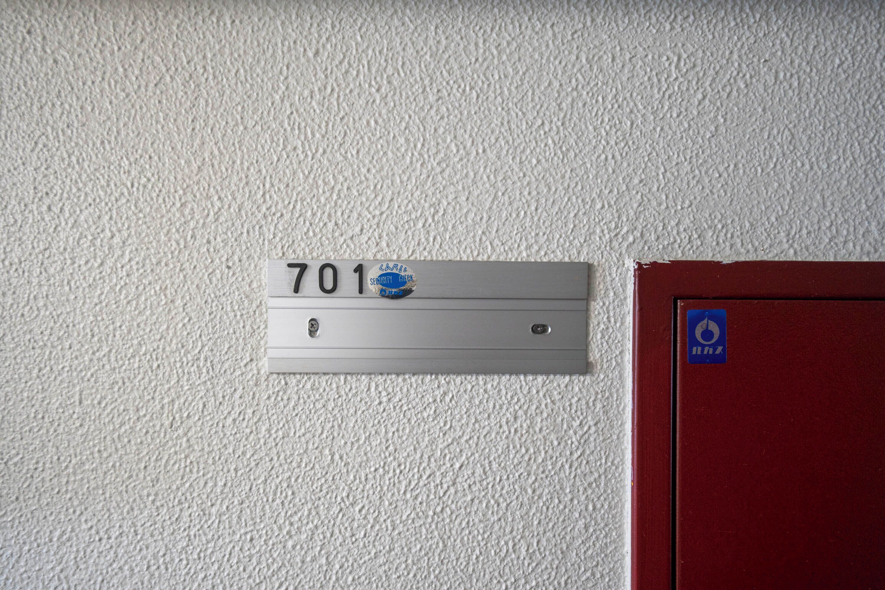 Segnaletica della stanza con un adesivo per controllo di sicurezza, un'indicazione di uscita di sicurezza e una porta.