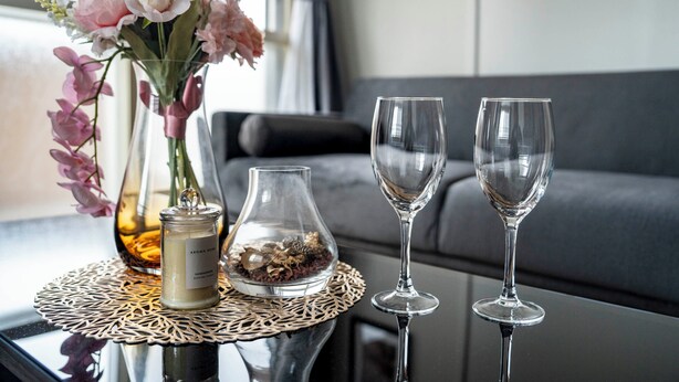 A table with a vase of flowers, a candle, and two wine glasses. - SPACE 701 (Sapporo)