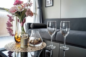 A table with a vase of flowers, a candle, and two wine glasses. - SPACE 701 (Sapporo)