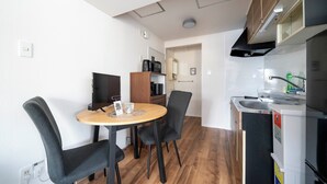 A compact kitchen with a dining area, wooden flooring, and modern appliances. - SPACE 701 (Sapporo)