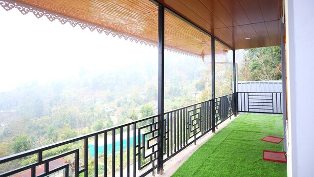 Un balcon donnant sur un paysage verdoyant et doté d’un plafond en bois.