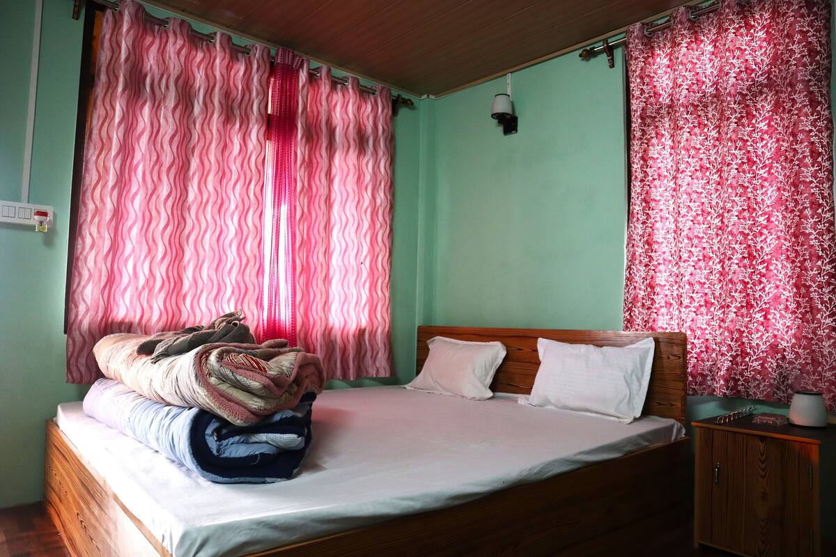 A single bed with a wooden headboard, a nightstand, and a small cabinet.
