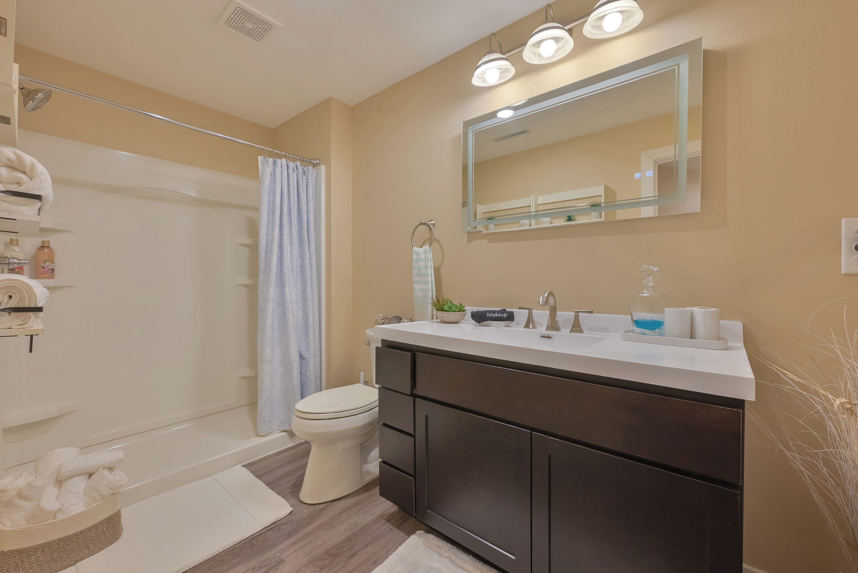 A modern bathroom with a bathtub, toilet, and vanity.
