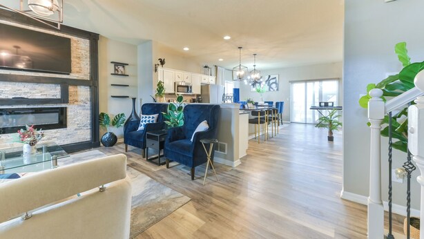 A spacious living area with a modern kitchen, a dining area, and a large window providing natural light. - Entire Home-Beautiful 4BR, 3.5BA Retreat in Ankeny, Iowa 2 King Beds, Fenced, AC (Ankeny)