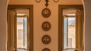 Un couloir avec un sol à carreaux, un lustre et quatre tableaux encadrés accrochés au mur.