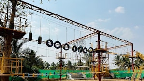 Une aire de jeux avec une structure d’escalade et des balançoires.