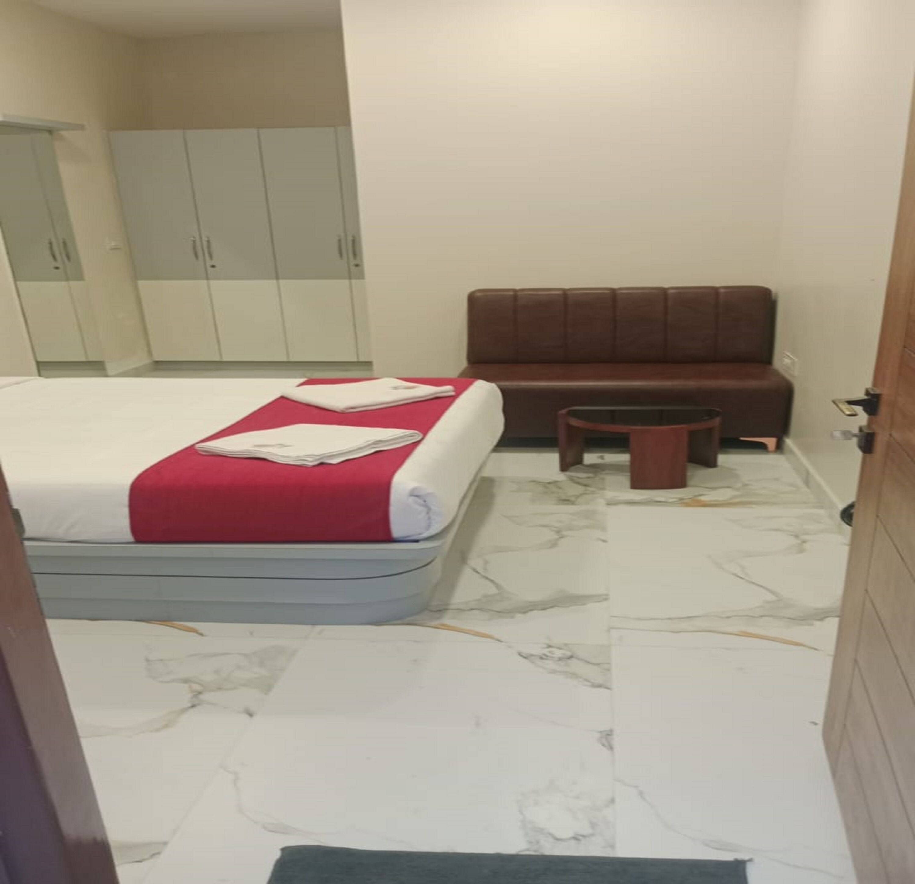 Un dormitorio con cama, una mesita, un sofá y un armario.