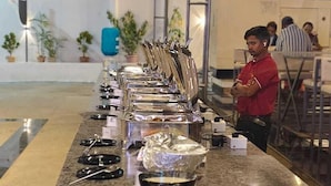 Un buffet proposant divers plats et couverts disposés sur un comptoir.