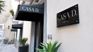A hotel entrance with a sign reading "CASAD HOTEL" and a black awning above the door. - Casa D Hotel Napoli (Naples)