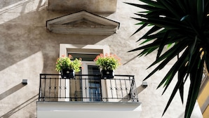 A balcony with two potted plants and a window. - Casa D Hotel Napoli (Naples)