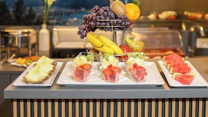 A buffet with various fruits and a mountain view in the background. - Casa D Hotel Napoli (Naples)