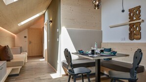 Un interior moderno con comedor, paredes de madera y techo inclinado.