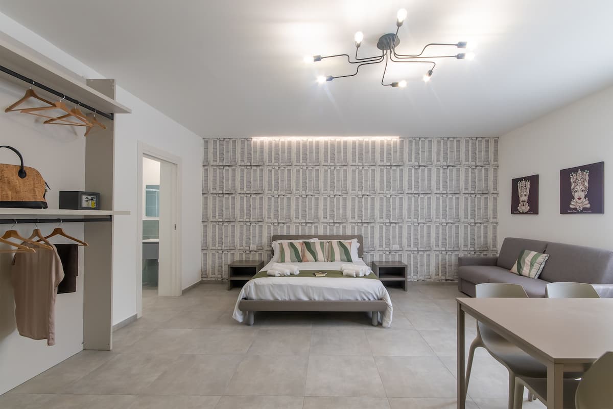 Une chambre moderne comprenant un lit, un canapé, une table à manger et une armoire.