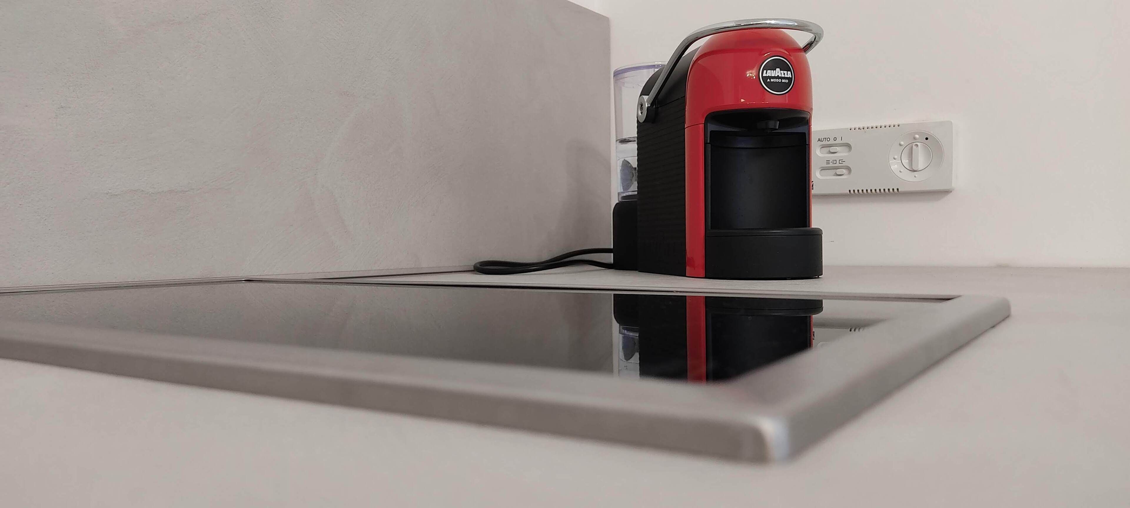 A coffee machine on a countertop with a power outlet nearby.