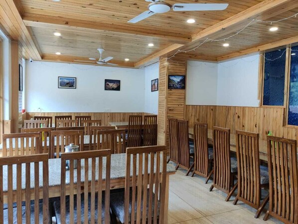 Un restaurante con mobiliario de madera y ventiladores de techo.