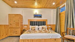 A wooden-paneled bedroom with a bed, a wardrobe, and a chair. - Hotel Sky Bhagsu (Dharamshala)