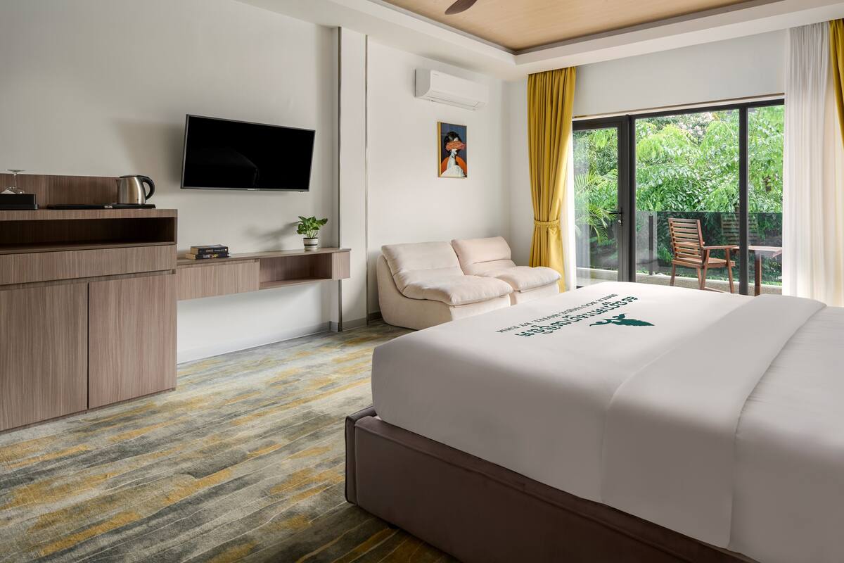 Une chambre d’hôtel avec un lit, une télévision, un bureau et une chaise.
