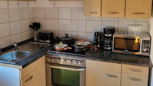 Une cuisine équipée d’une cuisinière, d’un four, d’un four à micro-ondes et de divers autres appareils.