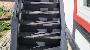 Un escalier menant à un bâtiment à la façade rouge et blanche.