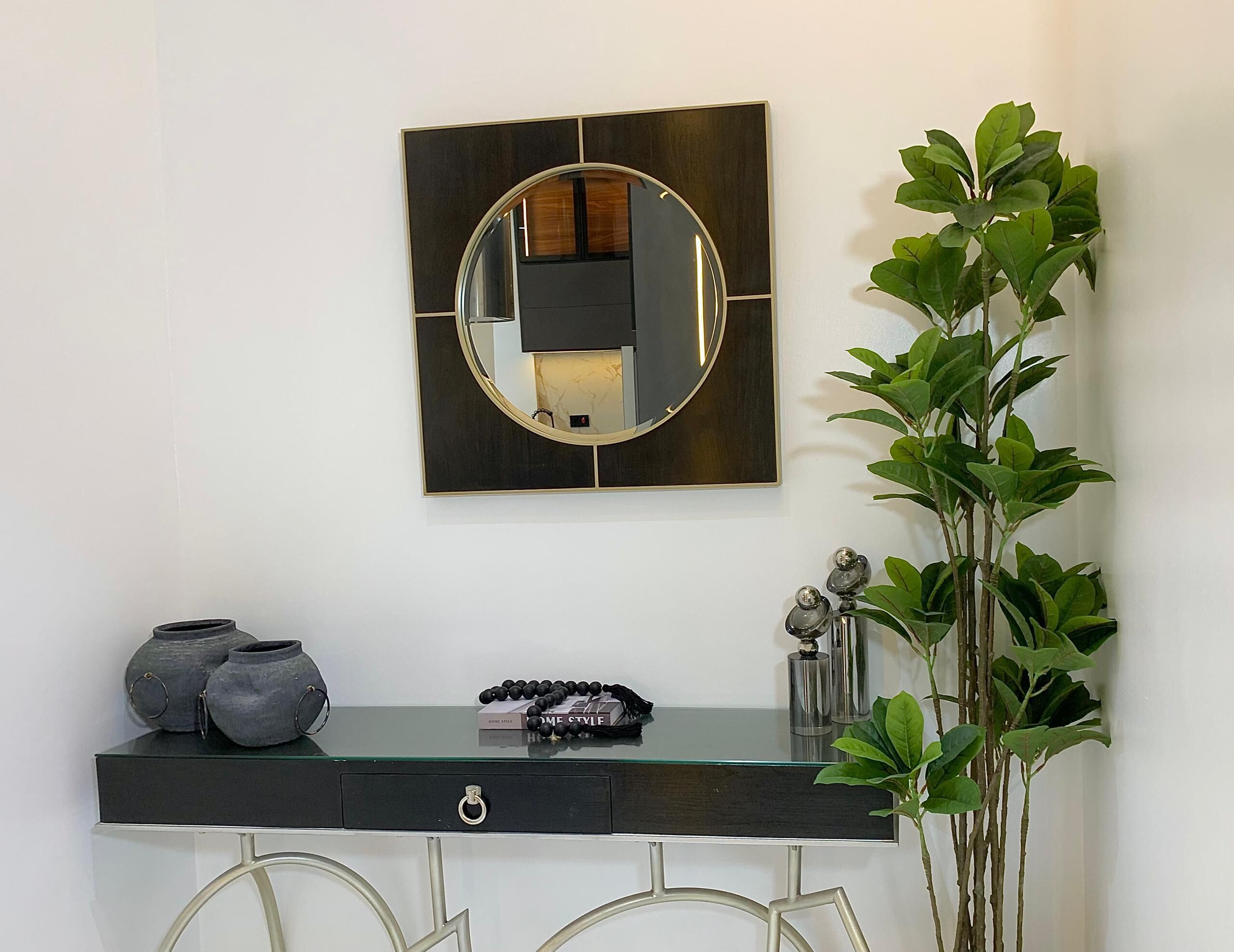 A modern vanity with a glass top, a dark console, and a large mirror.