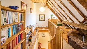 A cozy attic room with wooden bookshelves, a wooden desk, and a staircase. - Host Stay The Clock Tower (King's Lynn)