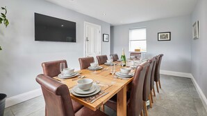 A dining room with a wooden table set for six, surrounded by leather chairs. - Host Stay Mount Cottage (Newcastle-upon-Tyne)