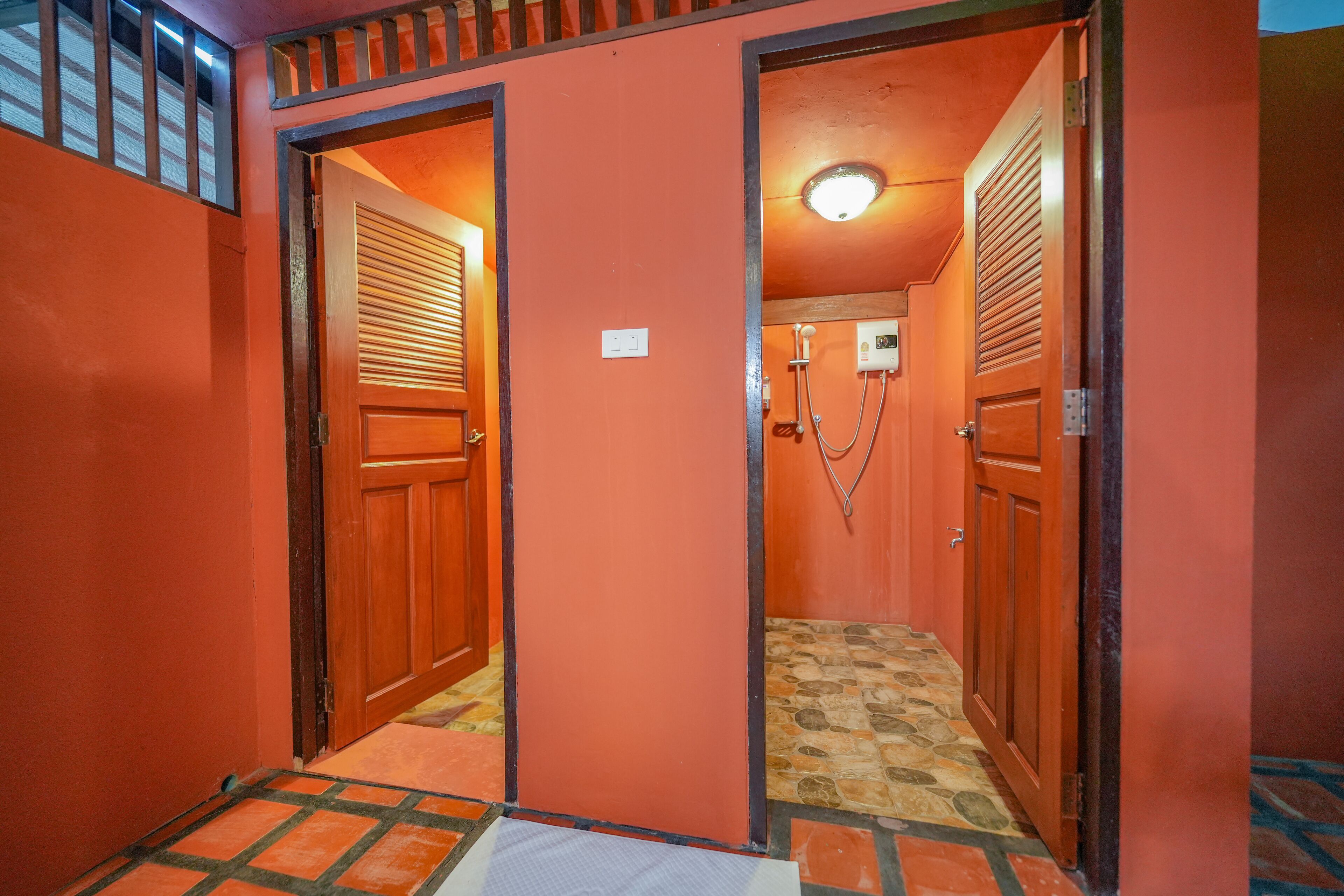 A hallway with two wooden doors, a tiled floor, and a ceiling light.