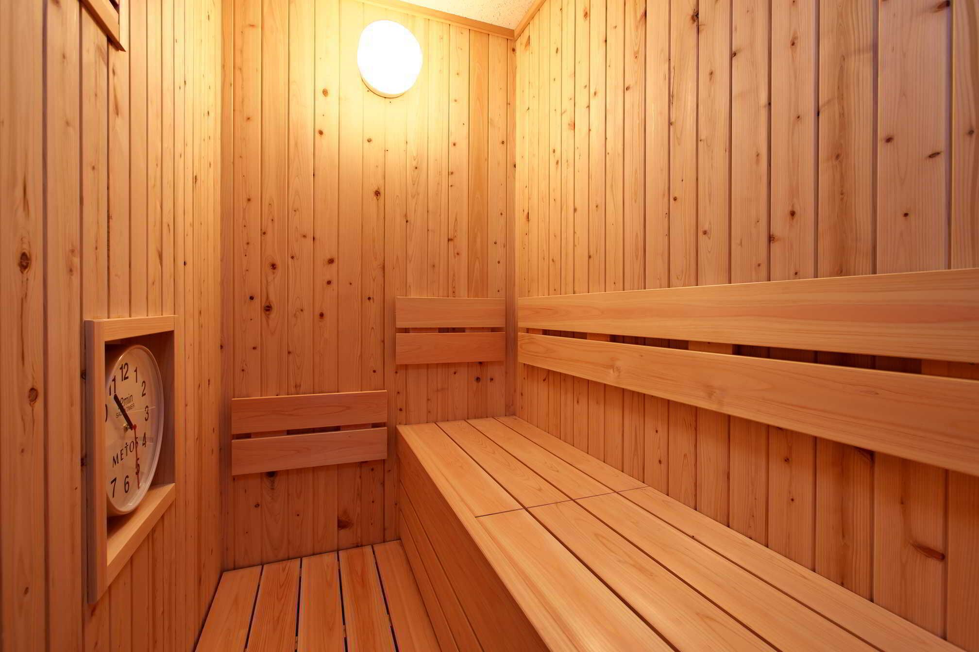 Un sauna en bois avec des bancs et une horloge.