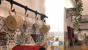A kitchen with a red coffee maker, a gas stove, and a tiled backsplash.