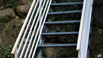 Una escalera de metal que conduce a un edificio con techo de metal corrugado.