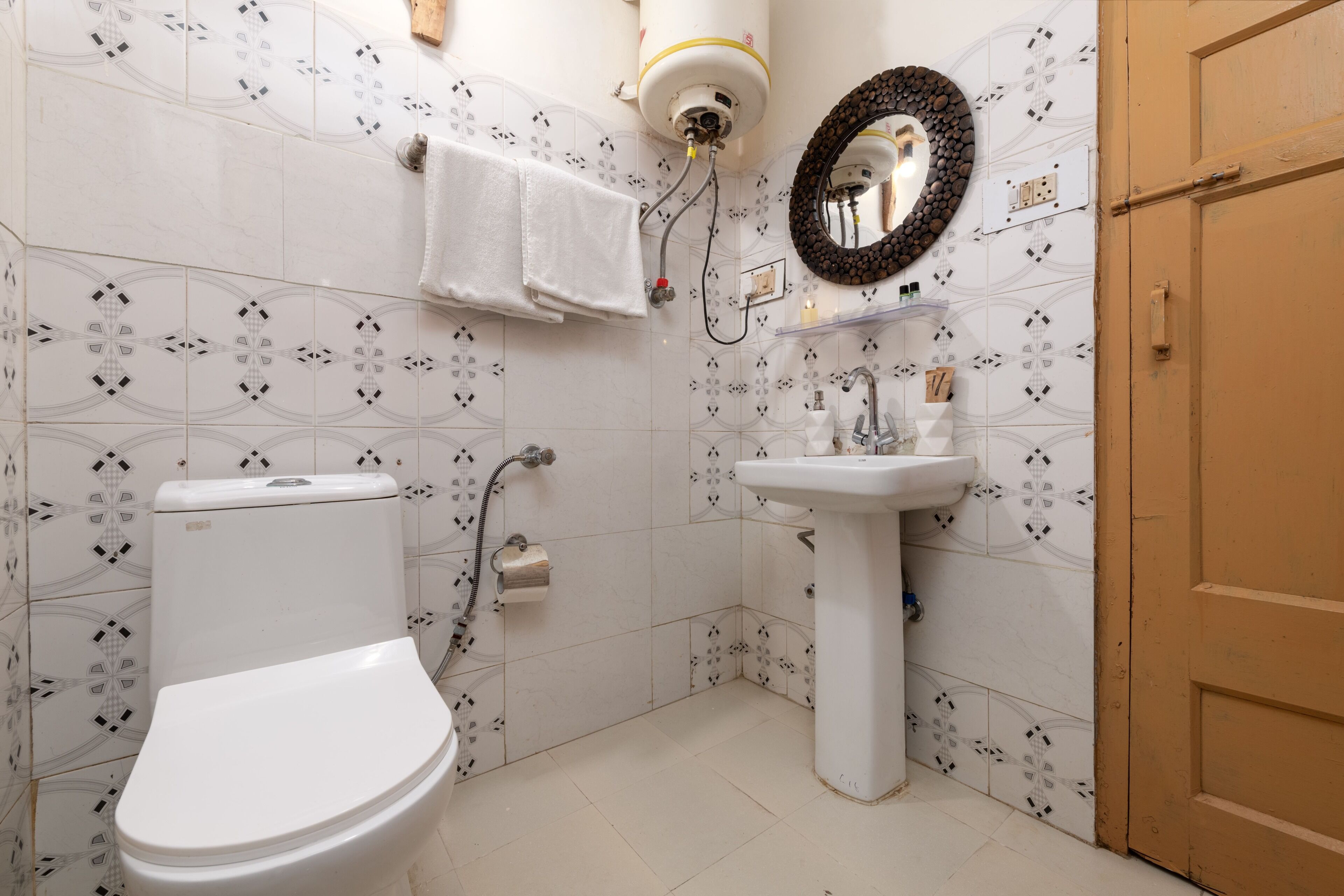 Une salle de bain équipée de toilettes, d’un lavabo et d’un porte-serviettes.
