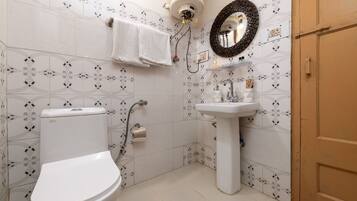 Une salle de bain équipée de toilettes, d’un lavabo et d’un porte-serviettes.