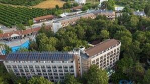 Un hotel con un patio central, piscina y un edificio grande de varios pisos y balcones.