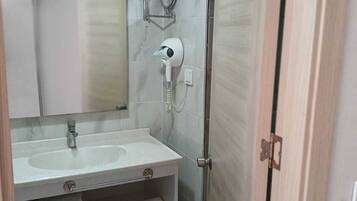 A modern bathroom with a white sink, mirror, and towel rack.
